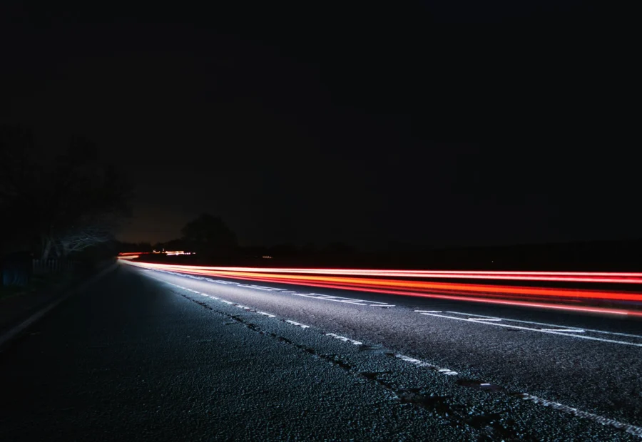 Strada di notte con scie luminose dei veicoli